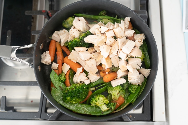 chicken stir fry in the pan on the stove top before being mixed together. 