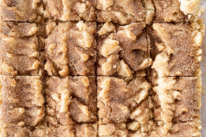 Snickerdoodle bars without icing cut into square in a baking pan.