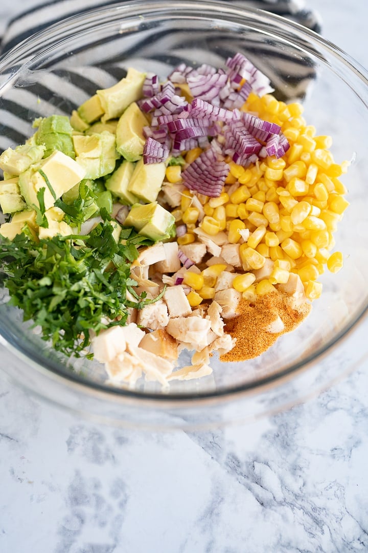 all of the ingredients in avocado chicken salad in a bowl on the counter. 