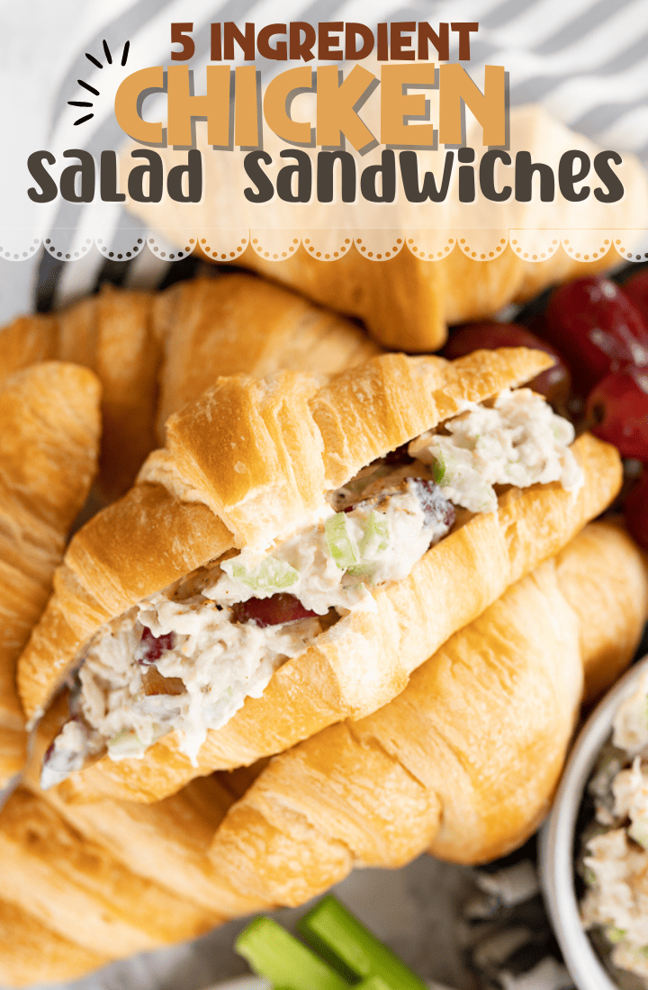 A stuffed chicken salad sandwich is on it's side with the filling facing up. Sandwich sits on additional crossiants, celery and grapes. Across the top it says "5 ingredient chicken salad sandwiches" 