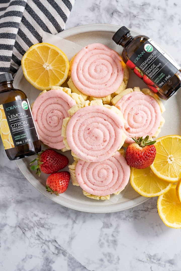 strawberry lemonade cookies with bottles of Lorann oils bakery emulsions next to the cookies. 