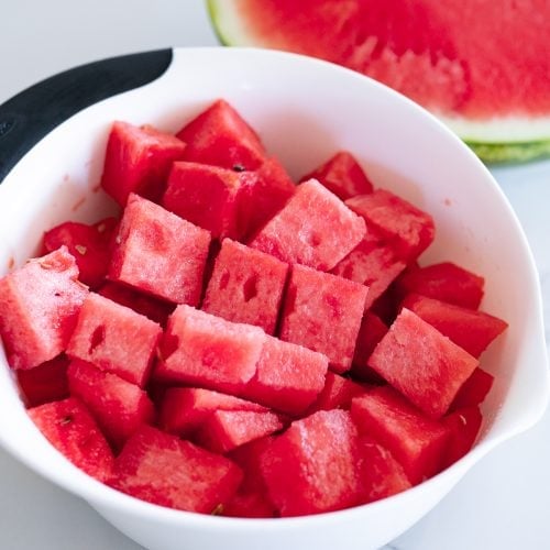 A bowl of perfectly cubed watermelon in a bowl.
