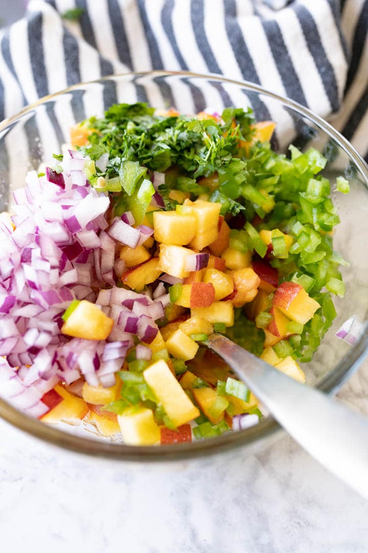 All the chopped ingredients for peach salsa together in a bowl prior to being mixed. 