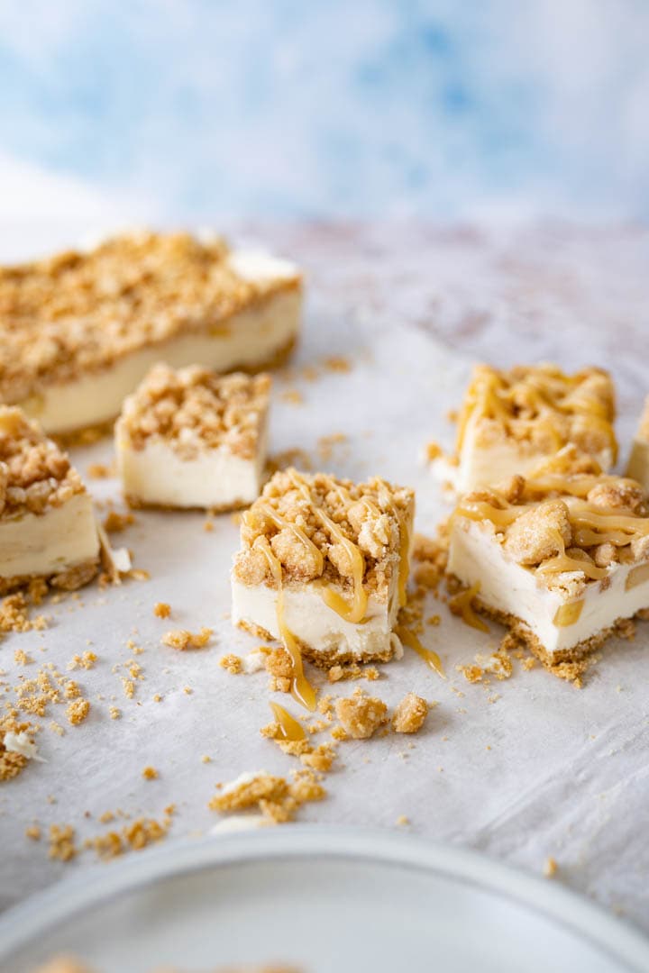 Multiple caramel apple cheesecake bars on the counter. 