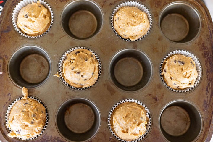 Aerial image of muffin batter piled high in a muffin tin prior to being baked. 