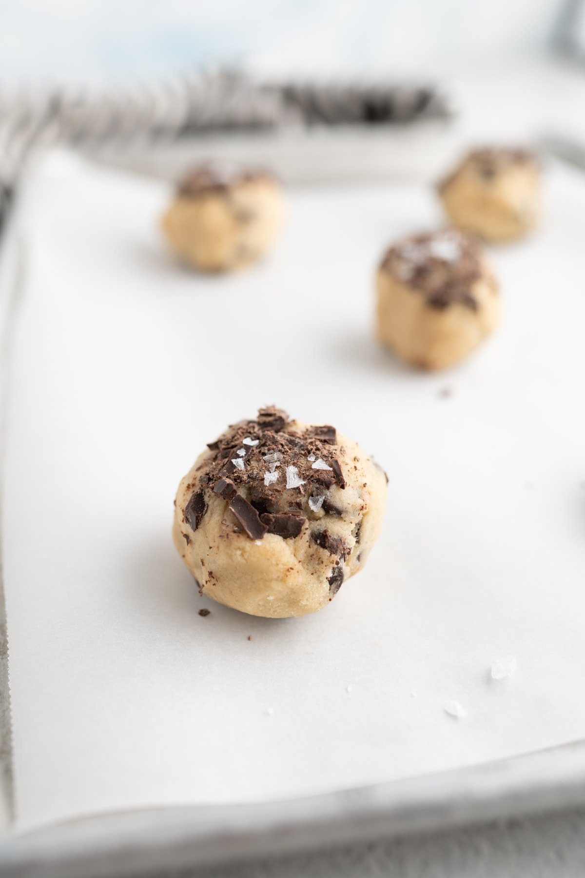 Jacques Torres Chocolate Chip Cookie dough balls on a prepared baking sheet. 