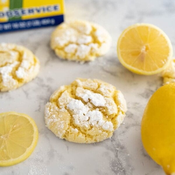 Lemon Crinkle cookies next to some sliced lemons.