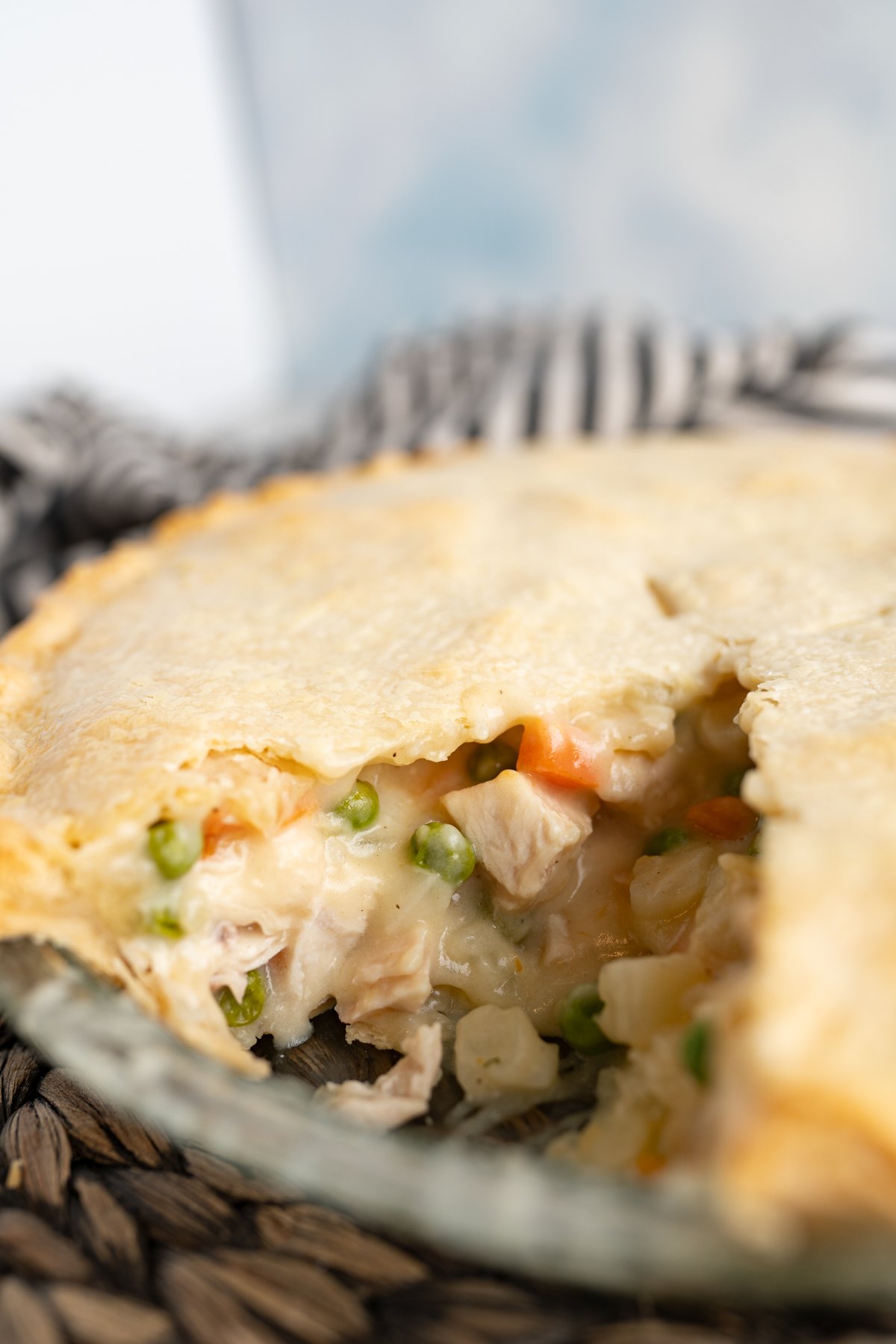 Side view of a chicken pot pie with one slice taken out of it. 
