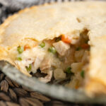 Side view of a chicken pot pie with one slice taken out of it.