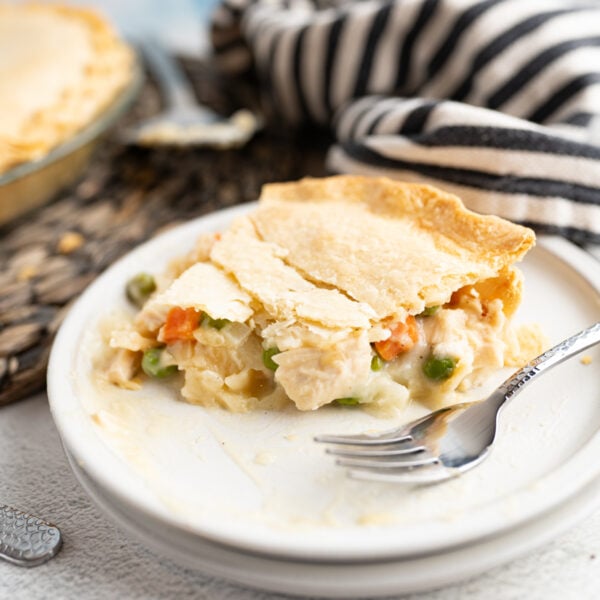 A slice of chicken pot pie on a plate with a fork.