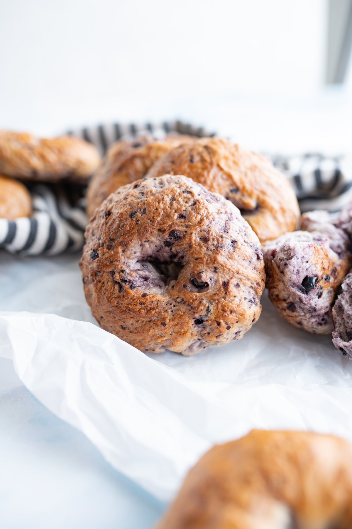 Homemade blueberry bagels stacked together on the counter. 
