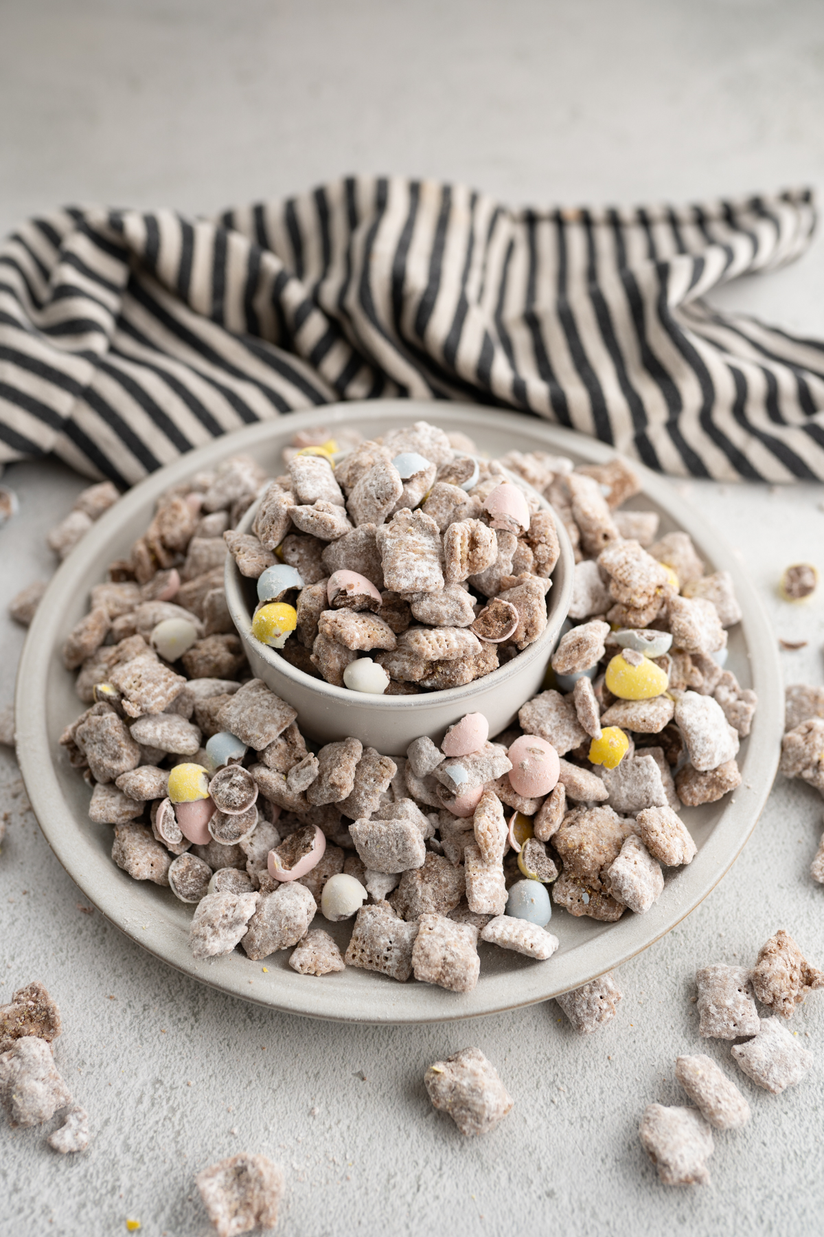 A serving tray full of muddy buddies with cadbury eggs on the counter. 