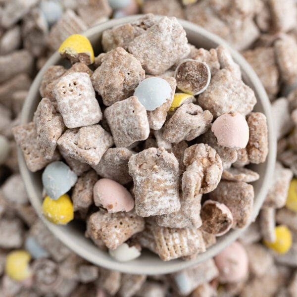 Aerial view of easter muddy buddies in a bowl overflowing onto a plate.
