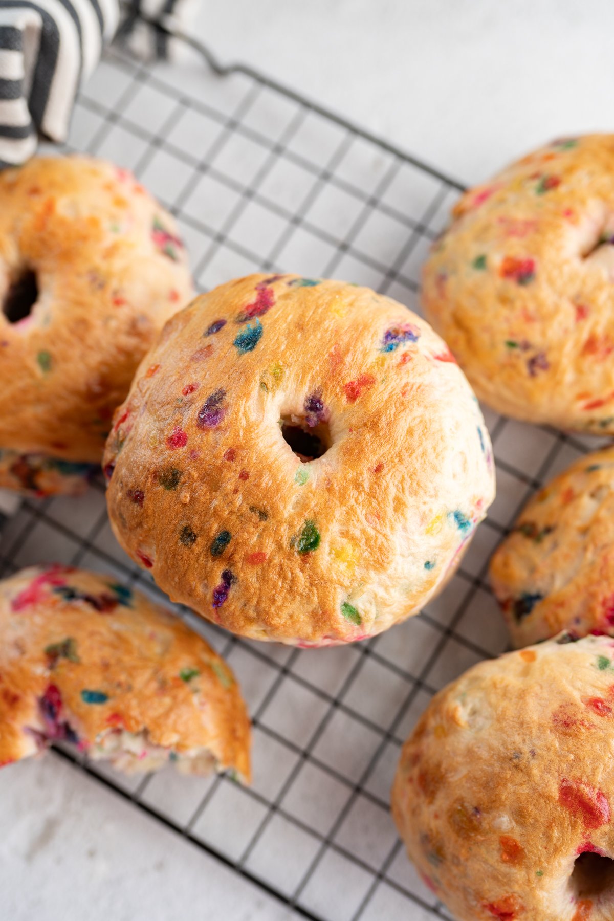 Aerial view of funfetti bagels on a wire cooling rack. 
