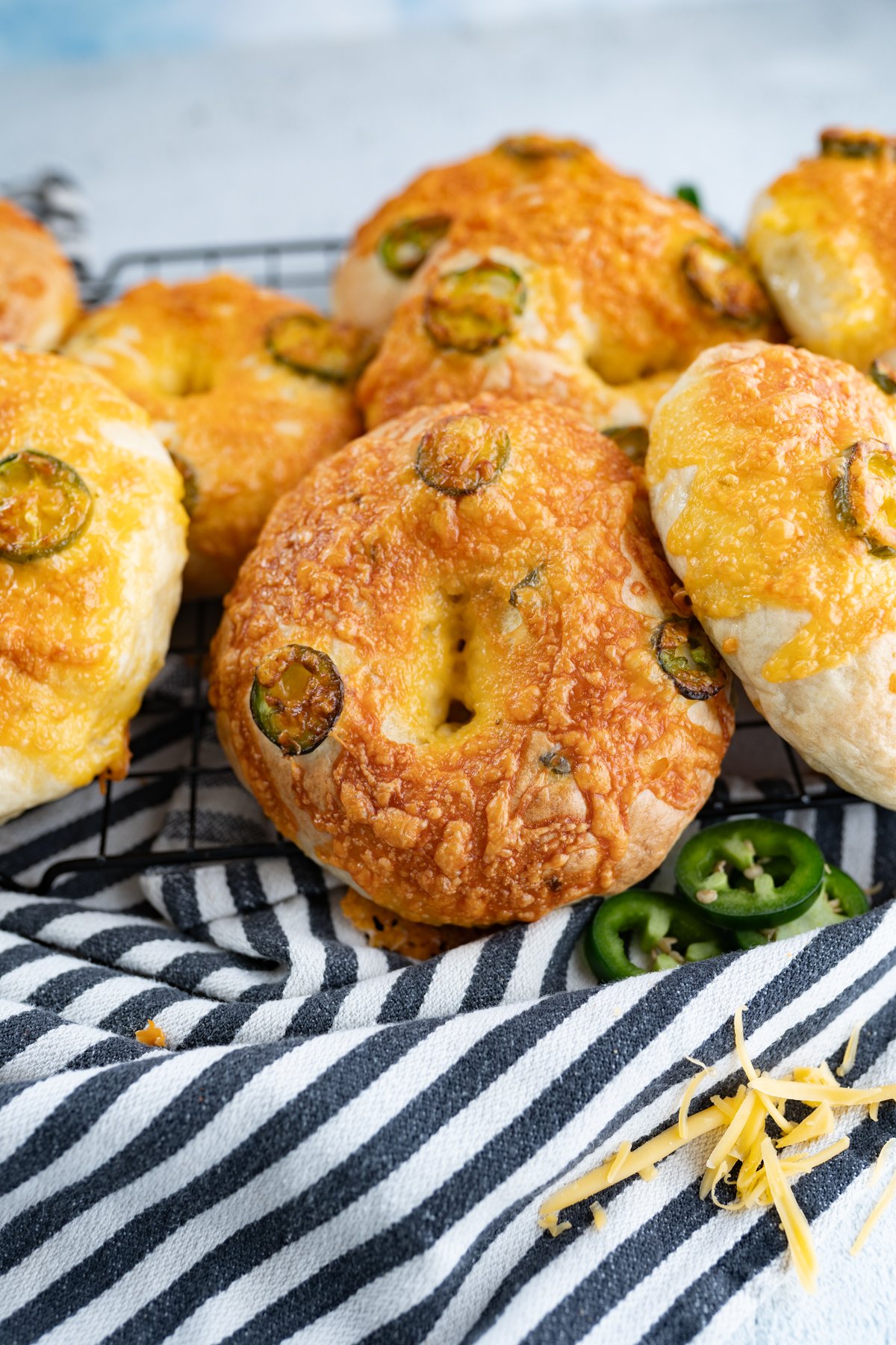 jalapeno cheddar bagels on a striped dish towel.