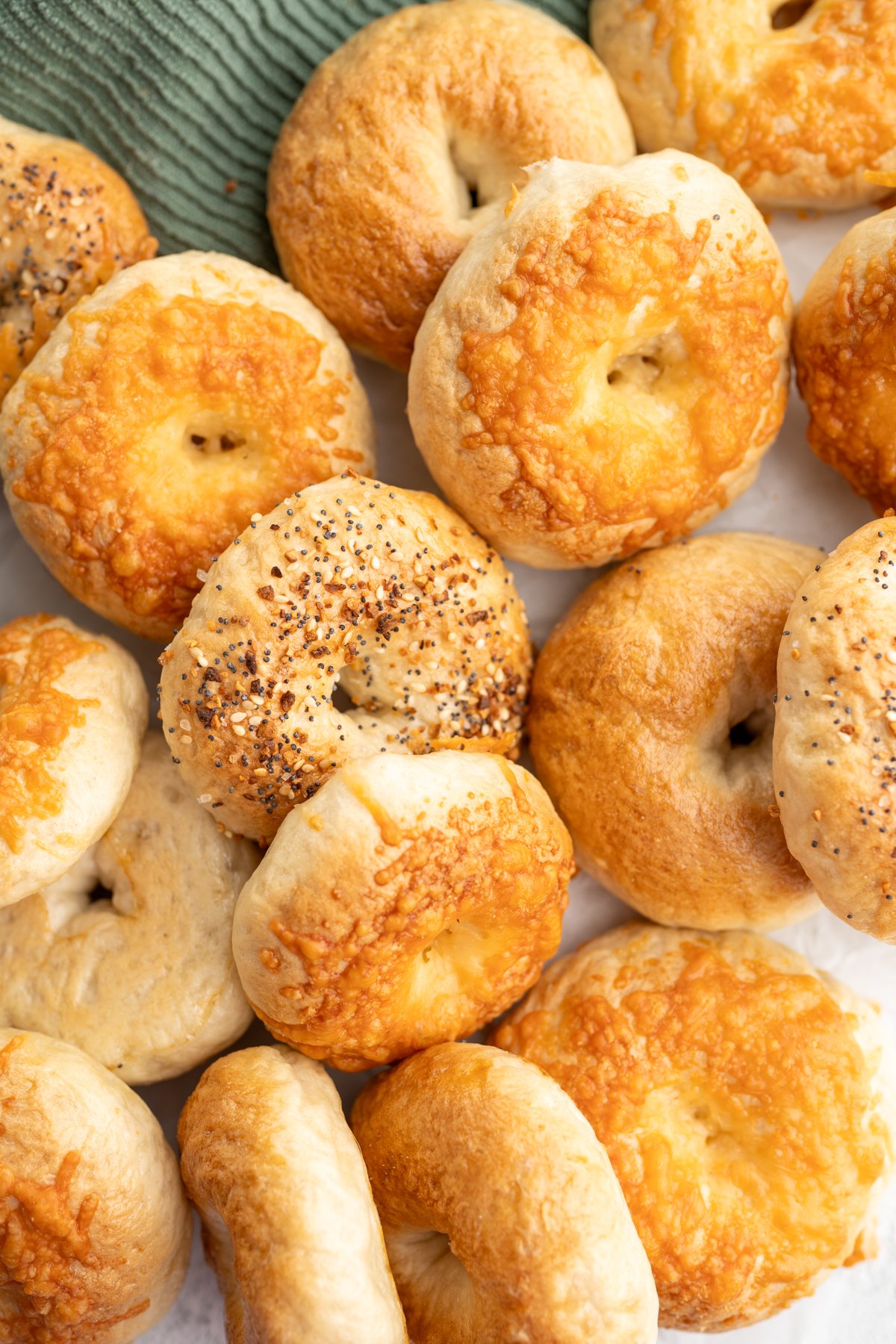 A pile of mini bagels on the counter. 