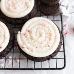 An chocolate oreo cookie with cream cheese frosting topped with crushed peppermint.