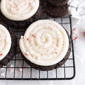 An chocolate oreo cookie with cream cheese frosting topped with crushed peppermint.