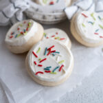 Christmas Loft house sugar cookies propped up on each other on the counter.