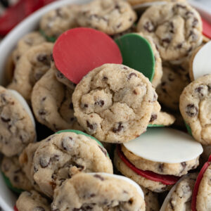 Close up of a bowl filled with mini cookies dipped in red and green chocolate.