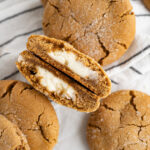 A gingerbread cookie cut in half to show it is stuffed with cheesecake filling.