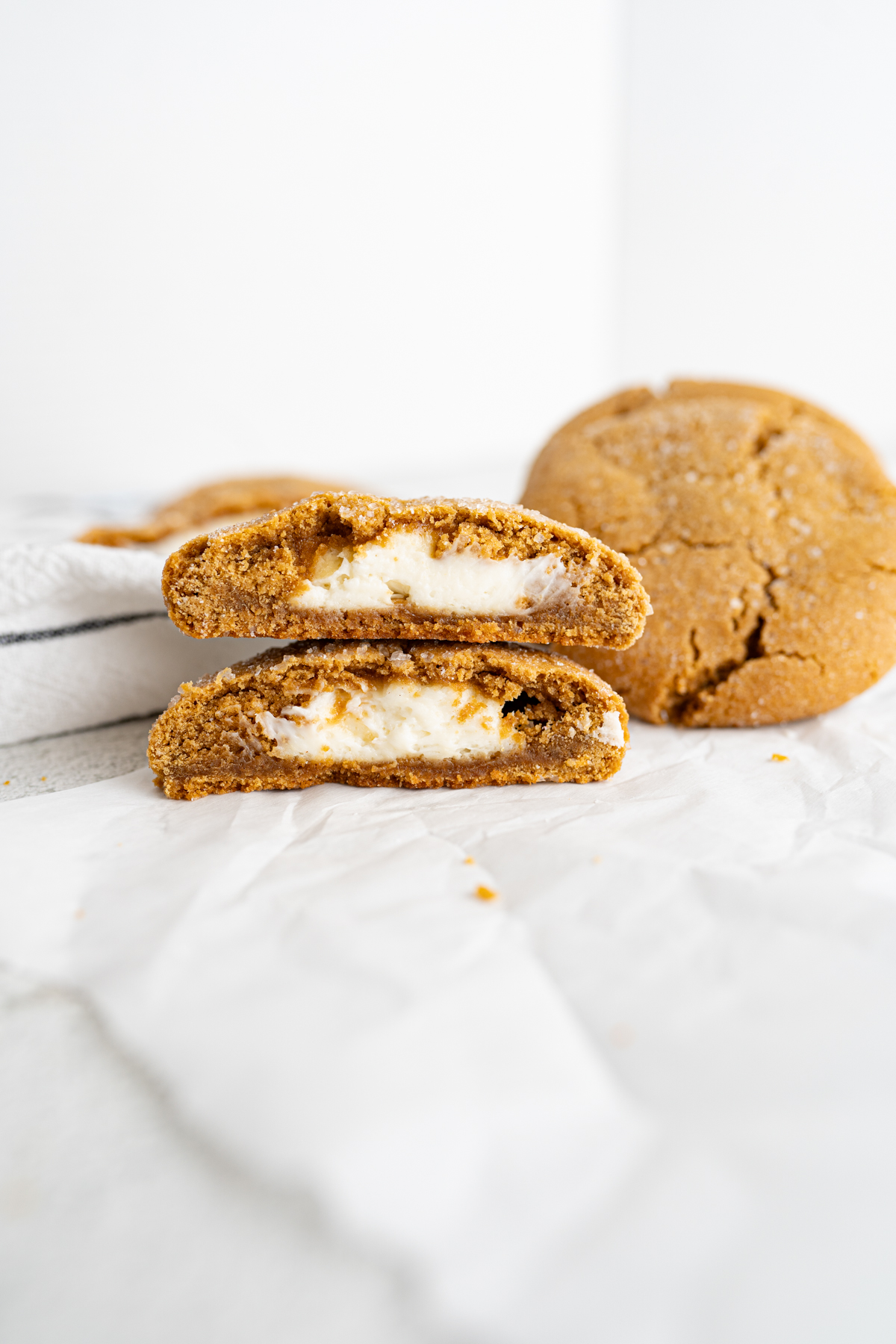A gingerbread cookie cut in half and stacked. the inside of the cookie has a cheesecake filling. 
