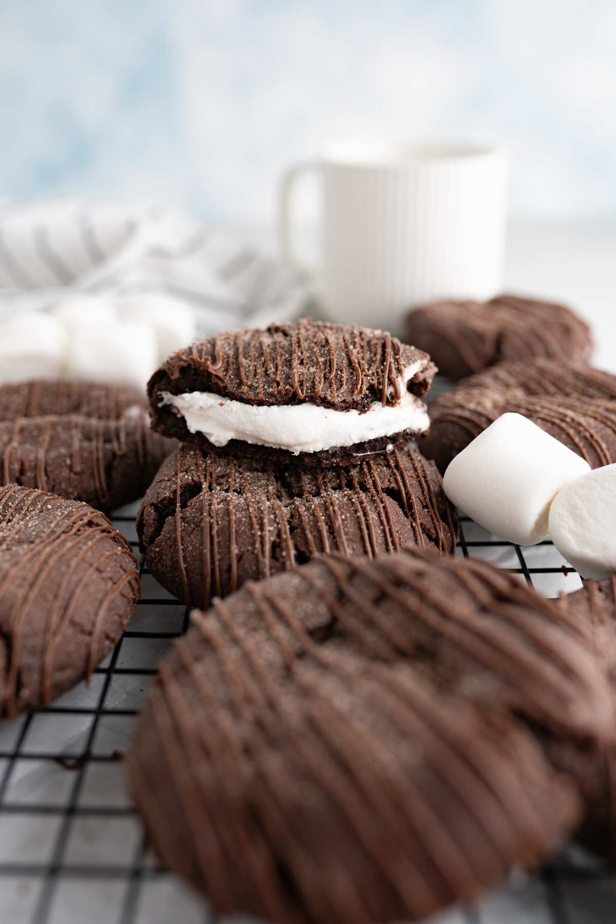 Hot chocolate cookie cut in half to reveal gooey marshmallow inside. 