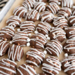 A tray filled with hot cocoa meltaway cookies drizzled with vanilla icing.