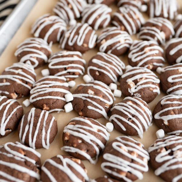 A tray filled with hot cocoa meltaway cookies drizzled with vanilla icing.