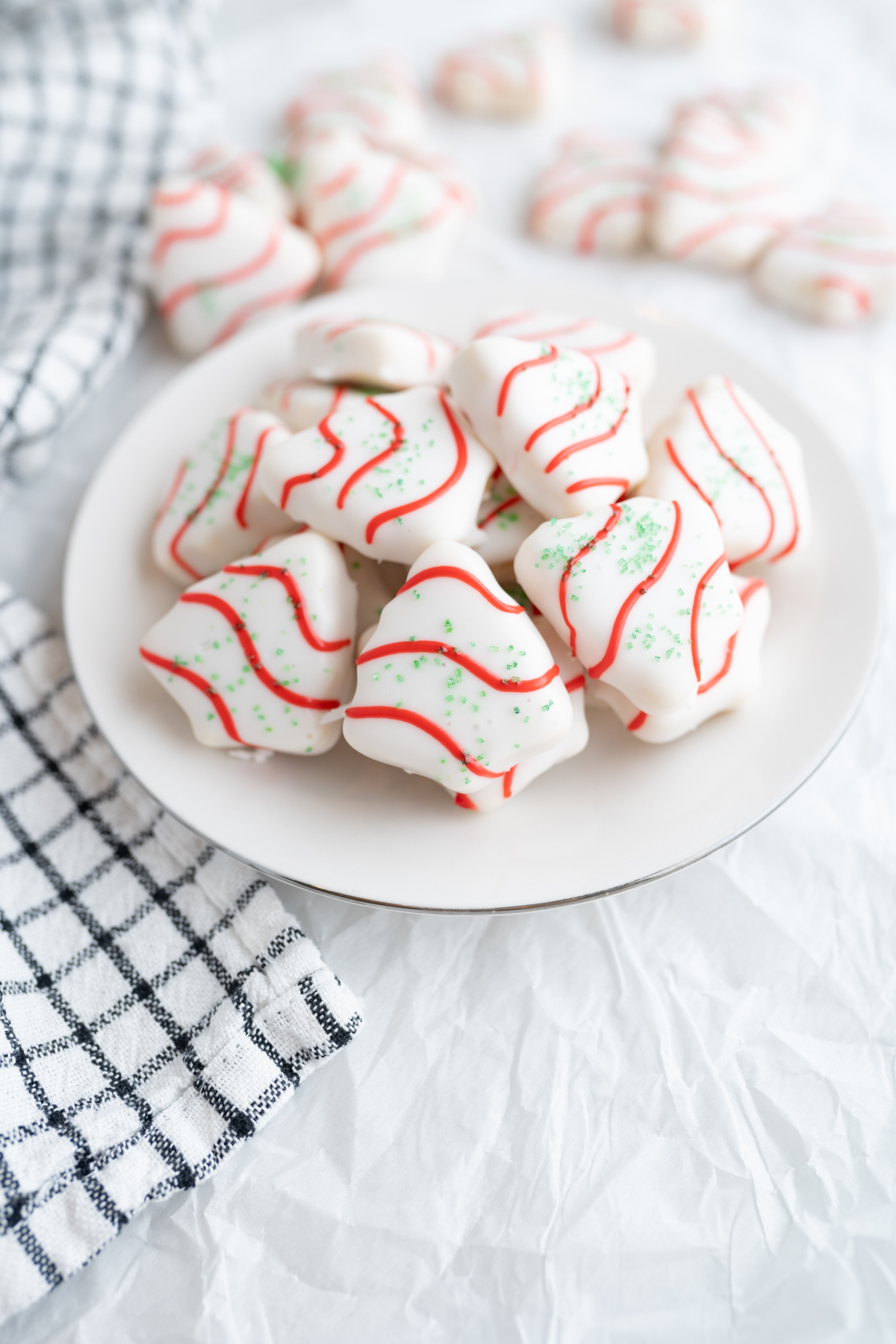A bowl of tiny cake batter sugar cookies decorated like little debbie trees 