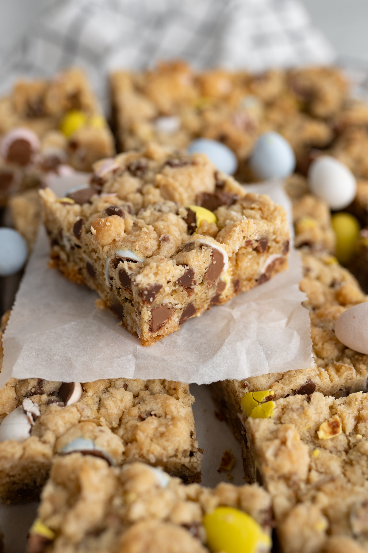Side view of a brown sugar and oats cookie bar revealing cadbury eggs and chocolate chips. 