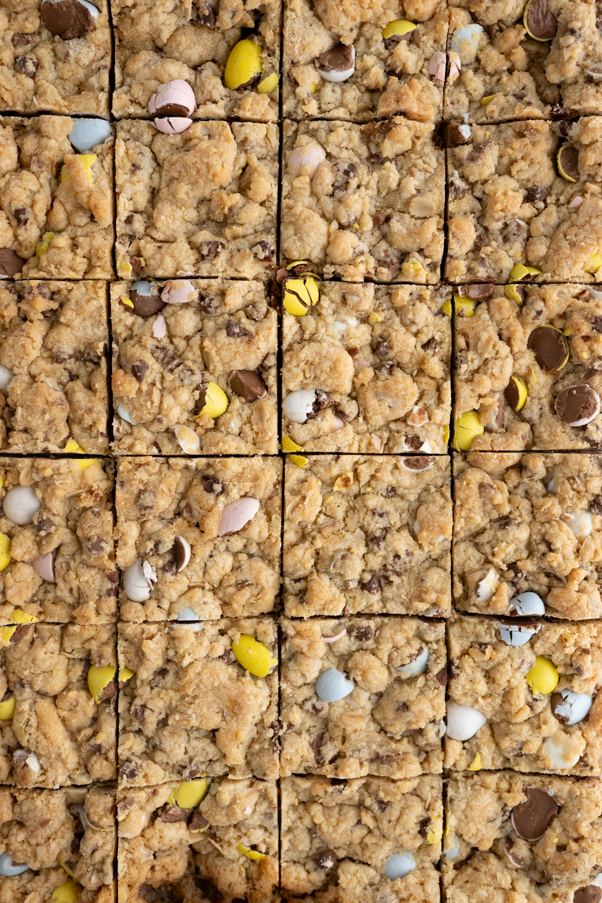 Aerial view of a tray of Cadbury Mini Egg cookie bars cut into squares. 