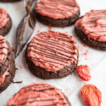A chocolate strawberry cookie topped with strawberry buttercream.