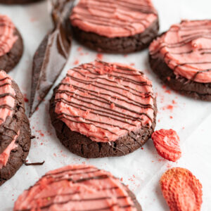 A chocolate strawberry cookie topped with strawberry buttercream.