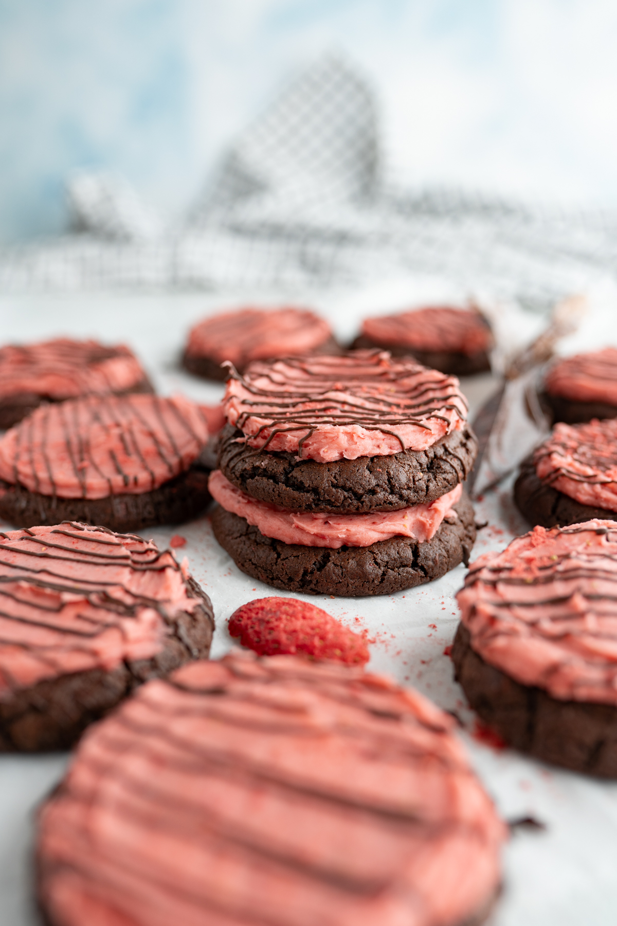 Side view of a stack of chocolate cookies with strawberry frosting. 