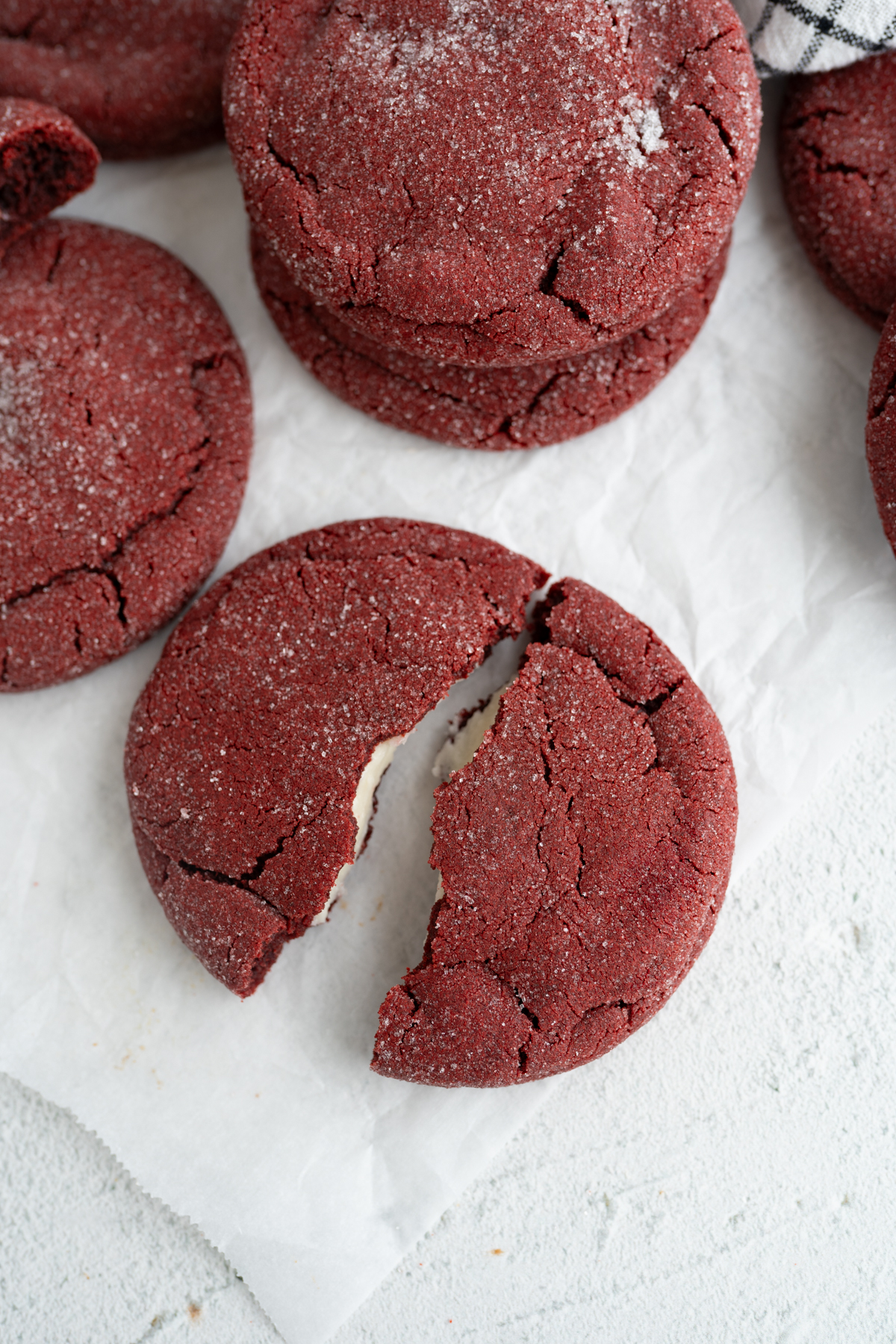 Aerial view of a red velvet cheesecake cookie cracked in half.