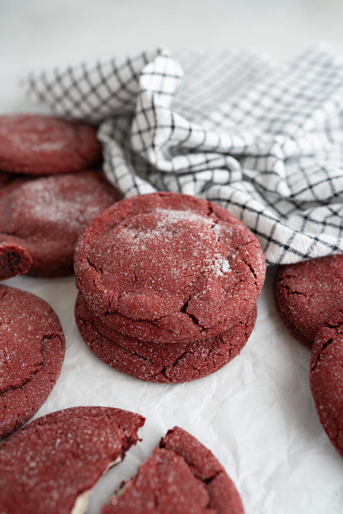 Aerial view of red velvet cookies rolled in granulated sugar and stuffed with cheesecake frosting.