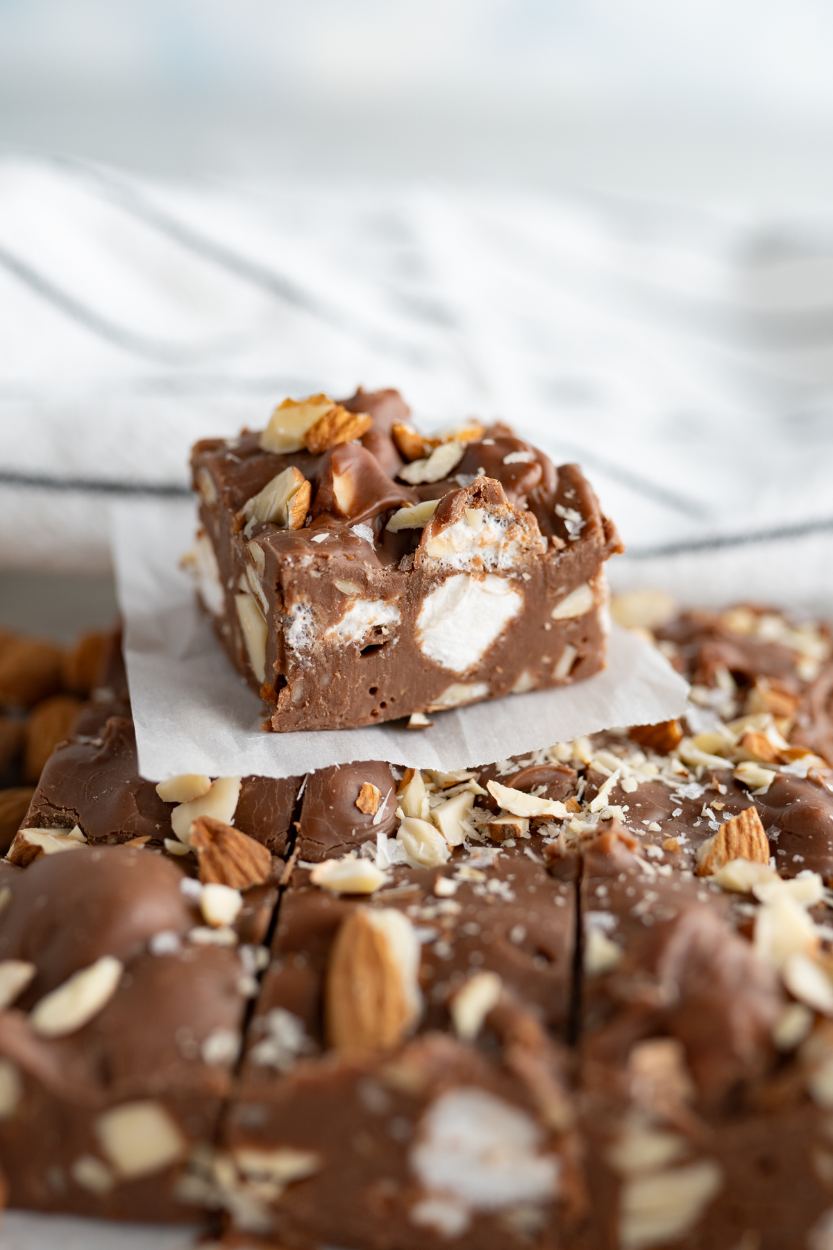 A single square of microwave rocky road fudge on top of more fudge.
