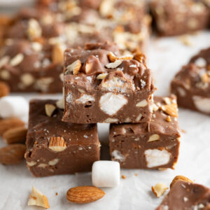 Close up of 3 rocky road fudge squares stacked on top of each other.