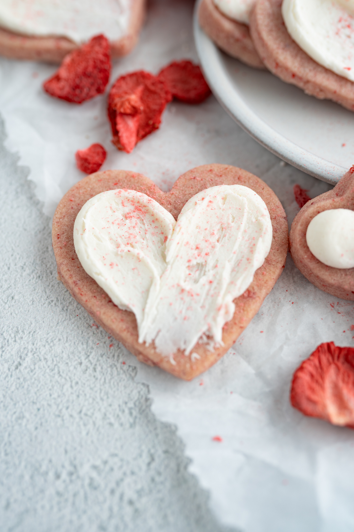 A single heart shaped pink strawberry sugar cookie. 