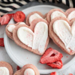 Strawberry sugar cookies cut out into hearts and frosted.
