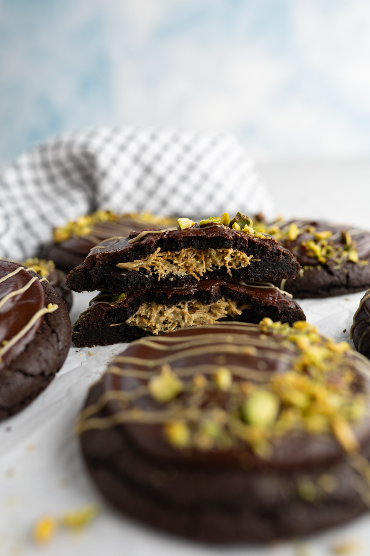 Side view of a dubai cookie cut in half to reveal a pistachio kataifi filling. 