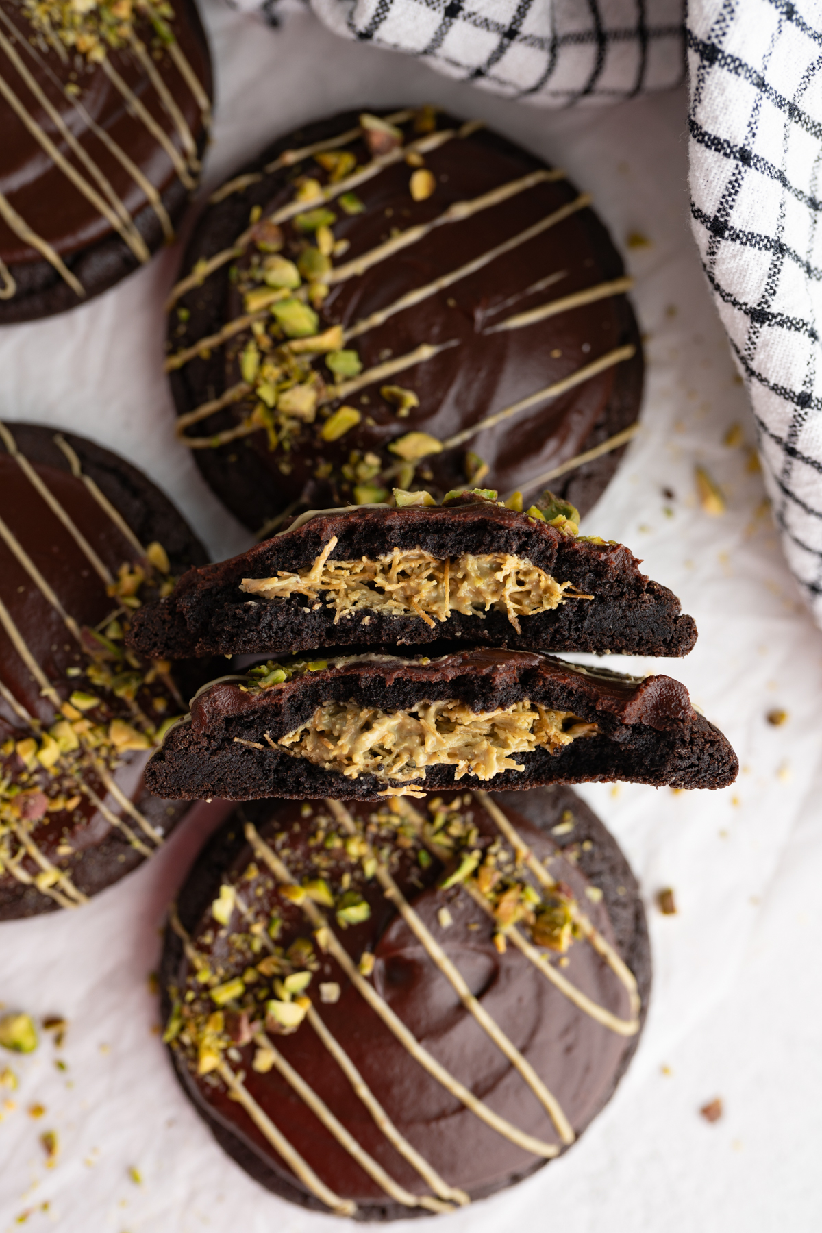 Aerial view of a dubai stuffed cookie cut in half propped up by full cookies. 