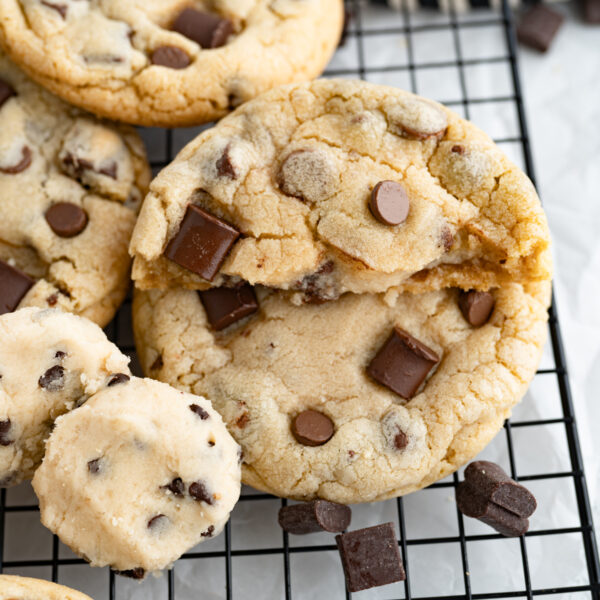 The ultimate chocolate chip cookie next to a ball of cookie dough filling.