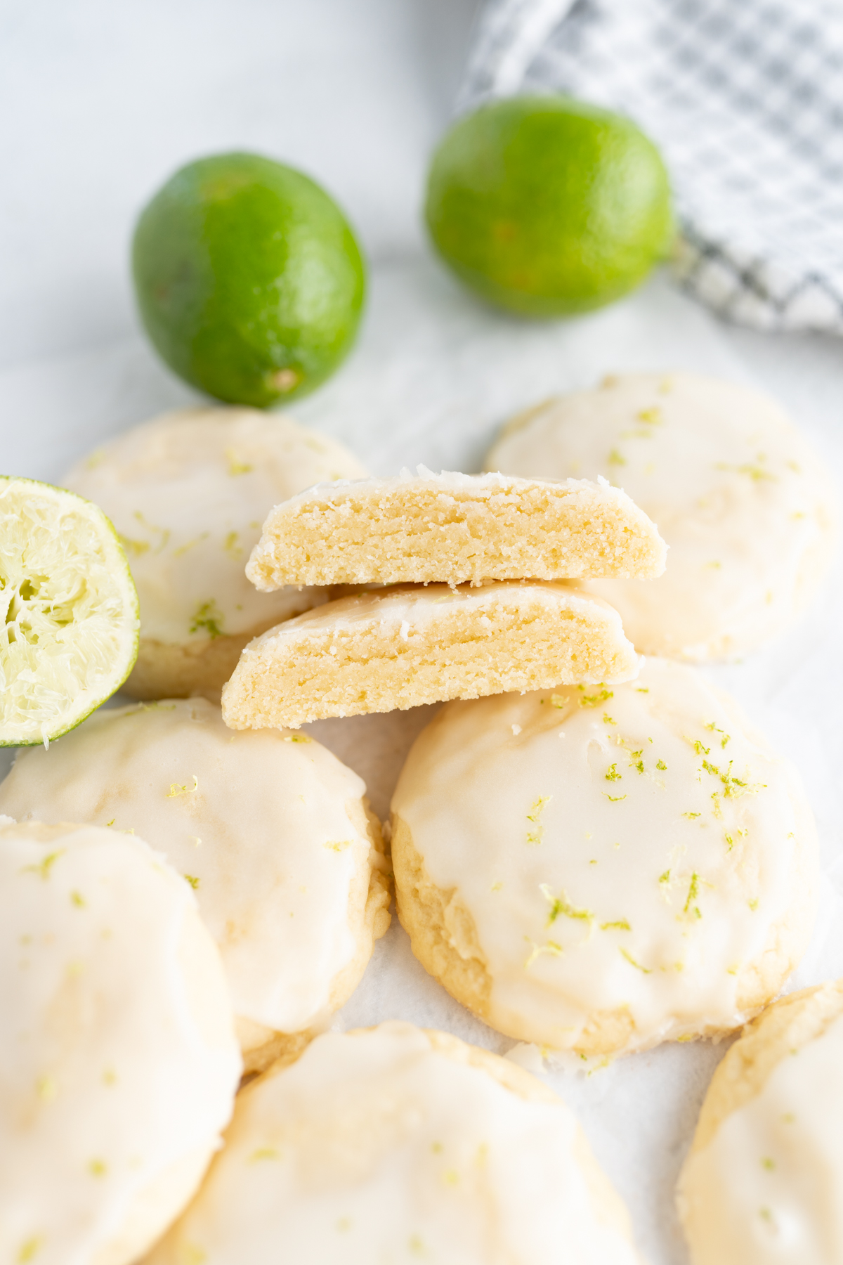 A coconut sugar cookie cut in half to show a soft interior. The cookie is topped with a lime glaze. 