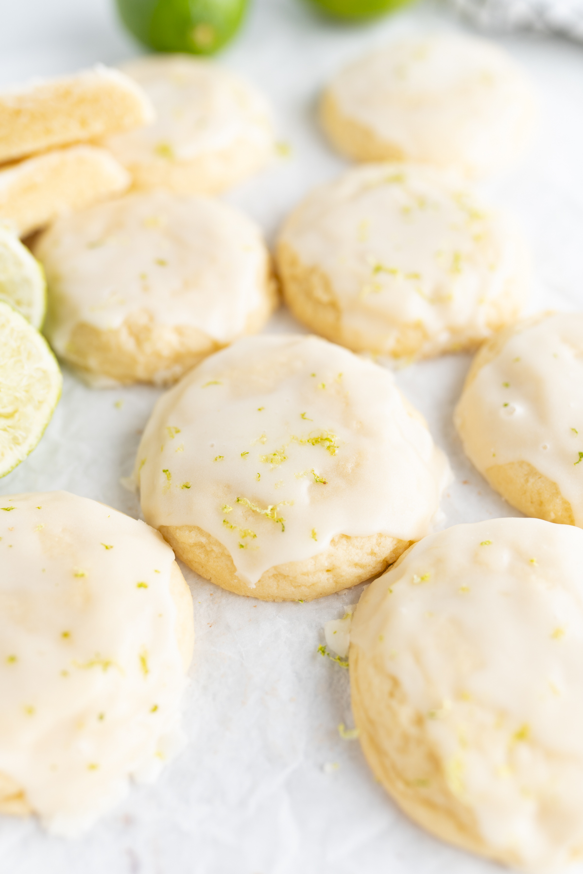 Aerial view of coconut cookies topped with lime icing spread on the counter top. 