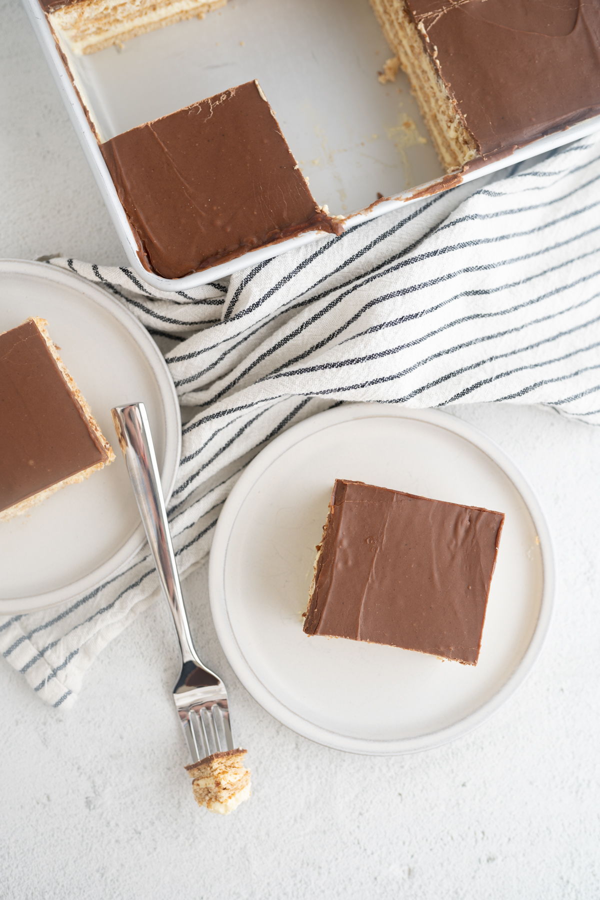 Aerial view of chocolate eclair squares cut and served on plates. 