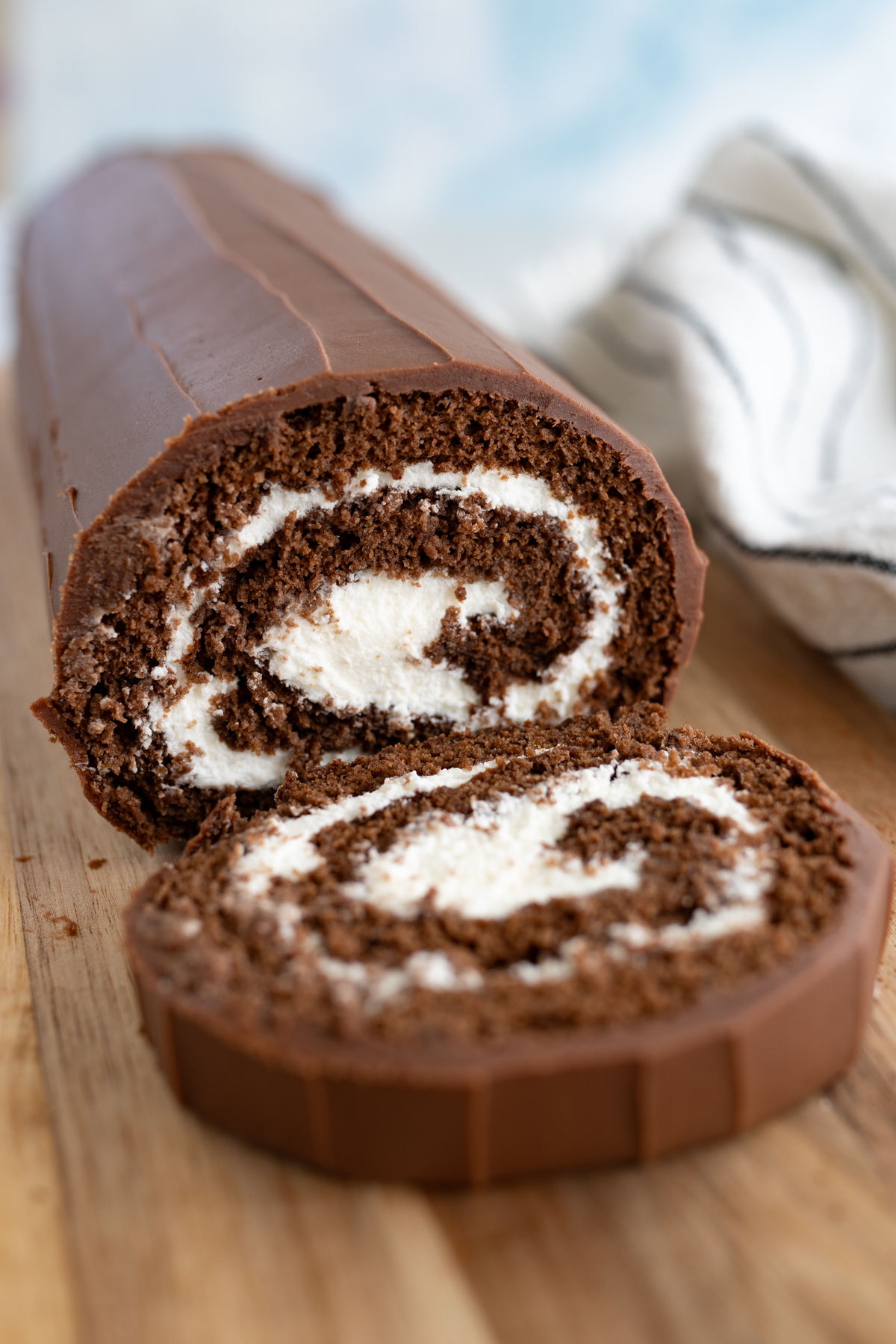 A swiss roll with a slice cut off to reveal the swirl. 