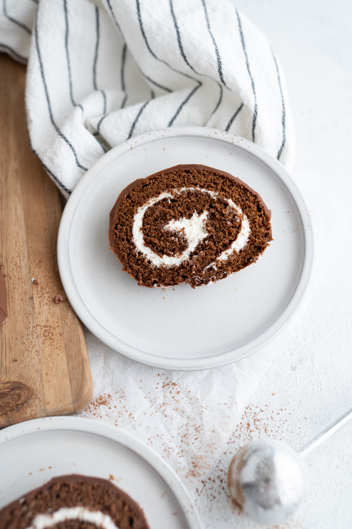 A single slice of a swiss roll on a plate. 