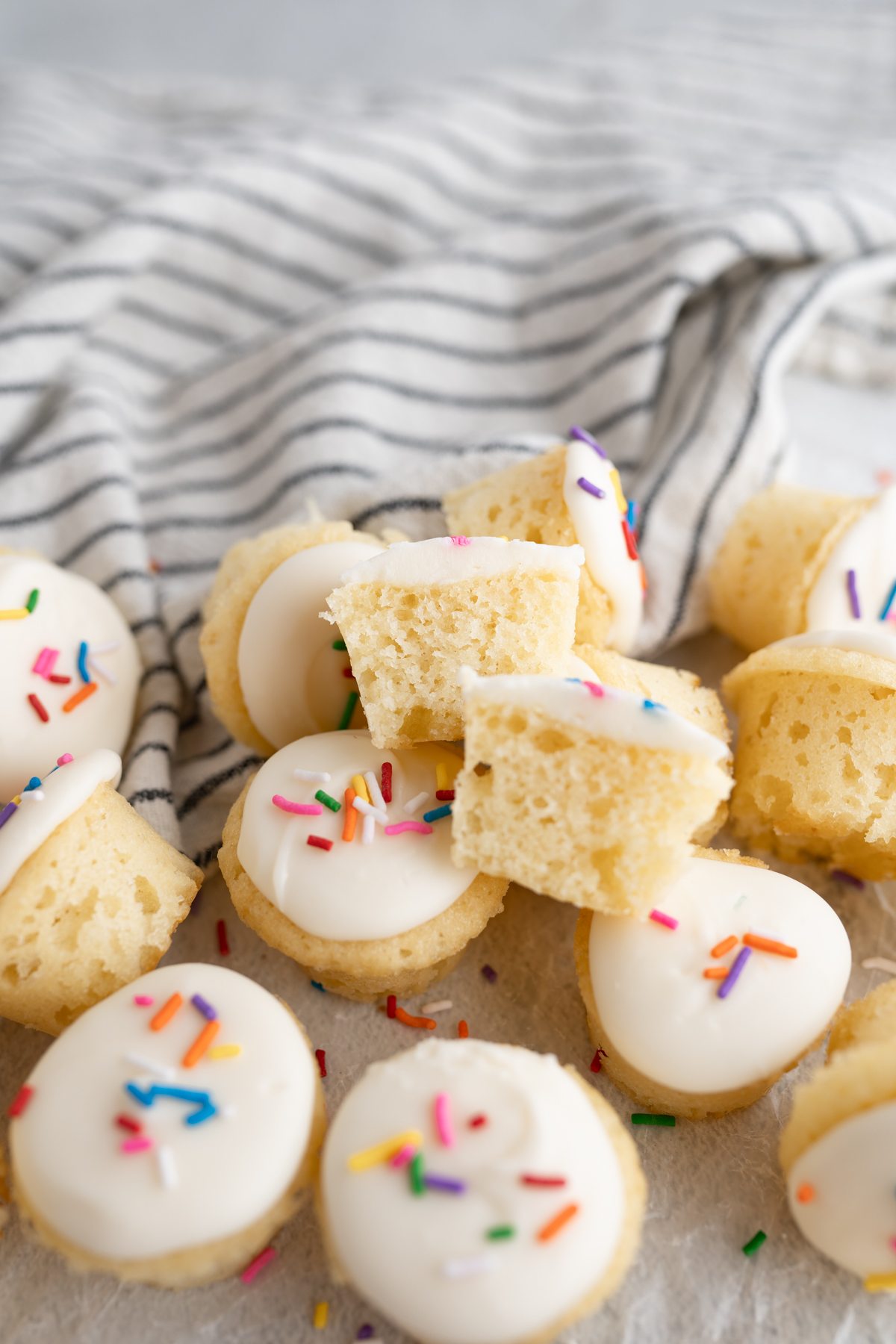 A mini vanilla cupcake cut in half to reveal a soft center. 
